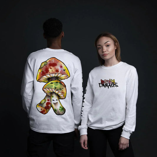 Male and female models show off the 'BRAIN DAMAGE' white long sleeve shirt, featuring a bold mushroom graphic on the back and playful front logo.