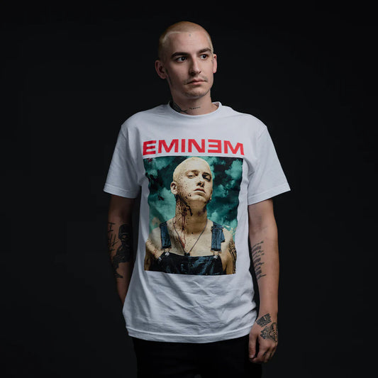 Male model with a contemplative expression wearing Eminem Bloody Chainsaw T-Shirt, showcasing a graphic print of Eminem with a blood-splattered background, symbolizing his intense lyrical style.