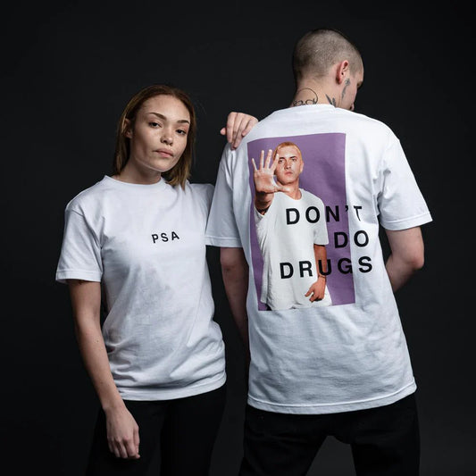 A male and female model in white PSA Eminem T-shirts, the male with a 'Don't Do Drugs' message featuring Eminem's image on the back, promoting a powerful public service announcement.