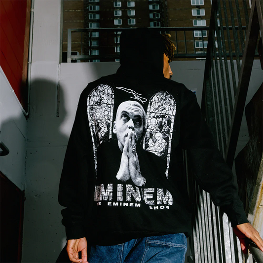 Rear view of a person wearing the Eminem Show 20th Anniversary Stained Glass Hoodie with intricate stained glass artwork, commemorating the iconic album.