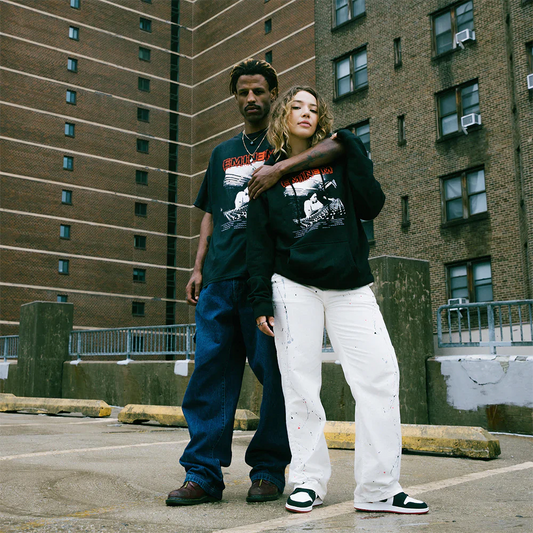 Two models posing confidently in an urban setting, donning 'The Eminem Show Studio' hoodies, showcasing the iconic album-inspired design.