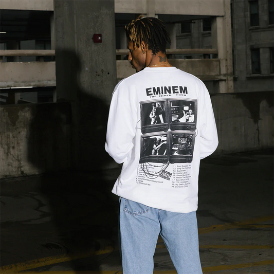 Model in urban setting sporting 'The Eminem Show Vintage TV Crewneck' with a monochrome print of classic television sets, evoking the album's era.