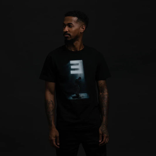 Eminem Stage Lights Graphic Black T-Shirt worn by male model, highlighting a silhouette of Eminem under spotlights.