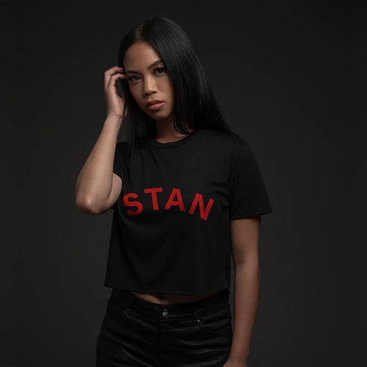 Female model posing in a black 'STAN' cropped t-shirt, a nod to Eminem's hit song, on a dark background.