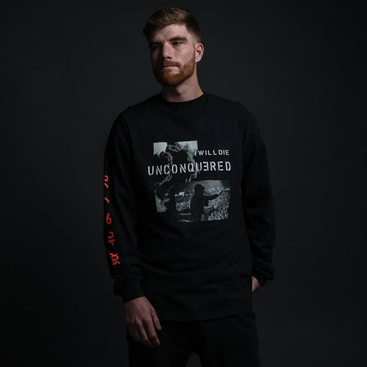 Male model in Eminem 'Unconquered' black long sleeve shirt with stark white text and image on the front, and red numerals along the sleeve.